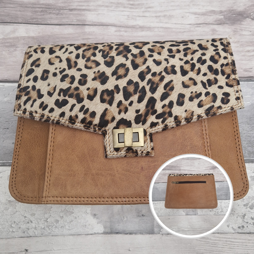 Leopard print clutch bag with a brown flap on a wooden surface