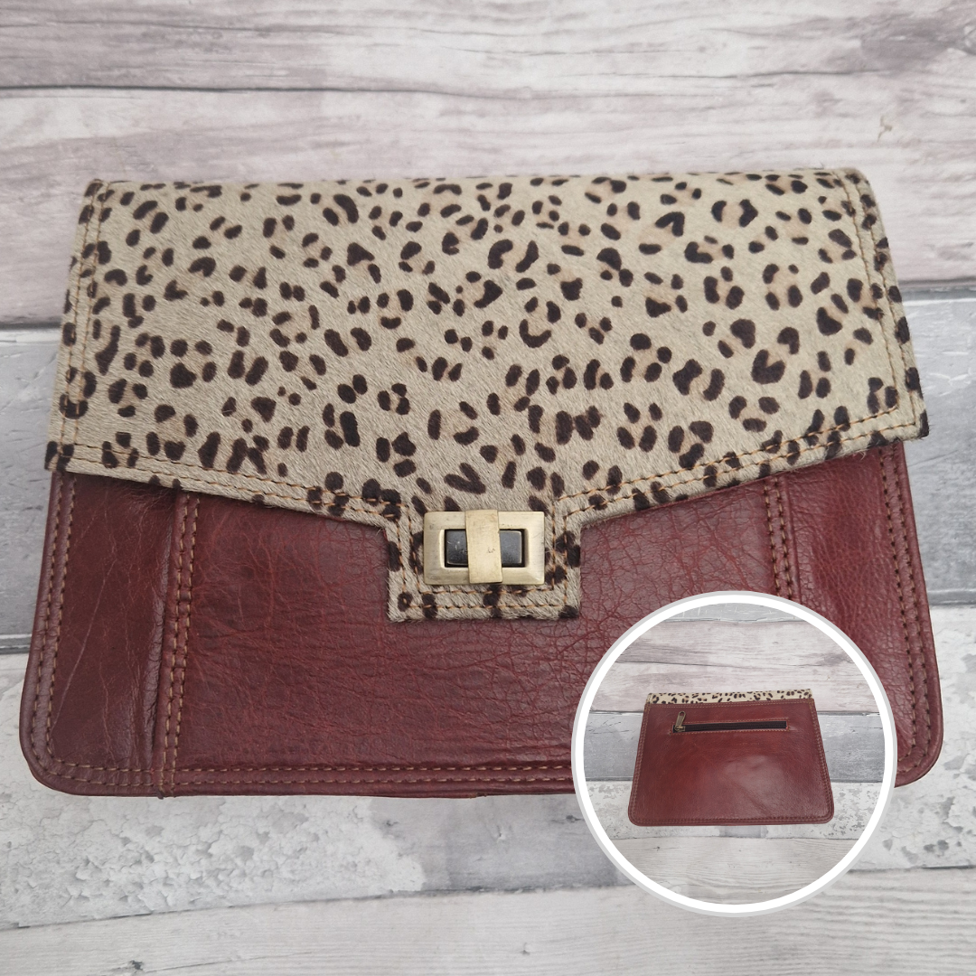 Burgundy leather Leopard print clutch bag with a close-up inset on a wooden surface
