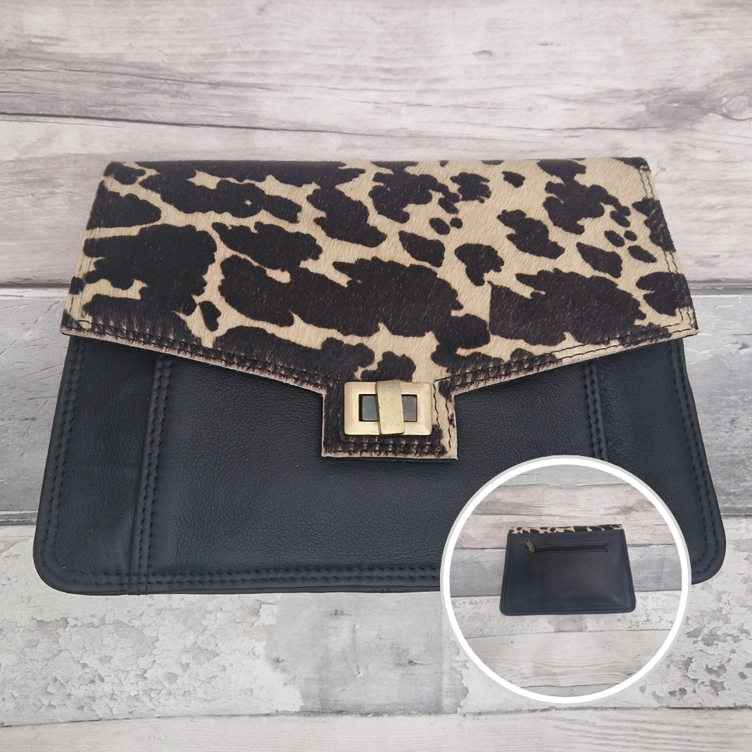 Leather  cow print clutch bag on a wooden surface with a close-up inset showing a black pouch.