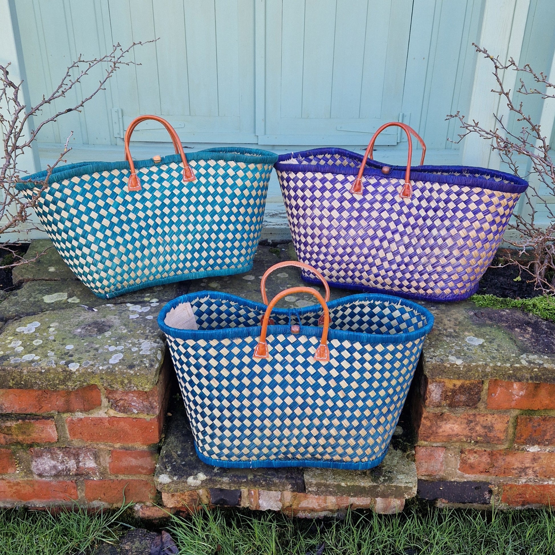 Three woven baskets with checkered pattern on a stone surface.
