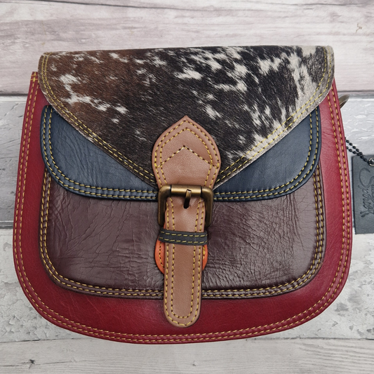 Saddlebag style bag in red coloured leather with contrasting coloured panels and a section of textured pony Print