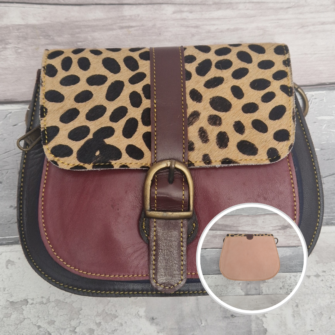 All leather saddlebag style ladies bag in 2 tones of brown and red with a textured panel of spot print. Brass buckle closer.
