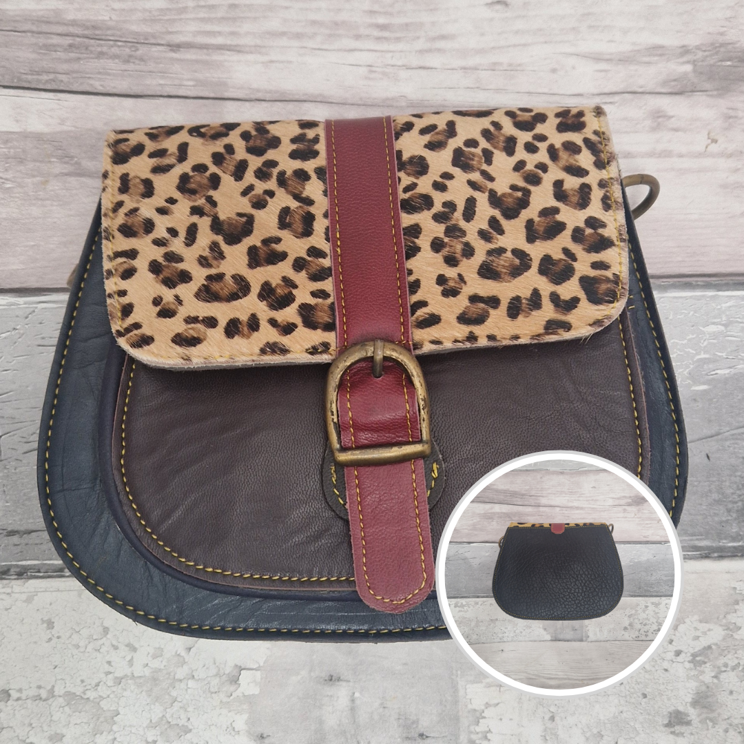 All leather saddlebag style ladies bag in 2 tones of brown and  navy with a textured panel of leopard print. Brass buckle closer.
