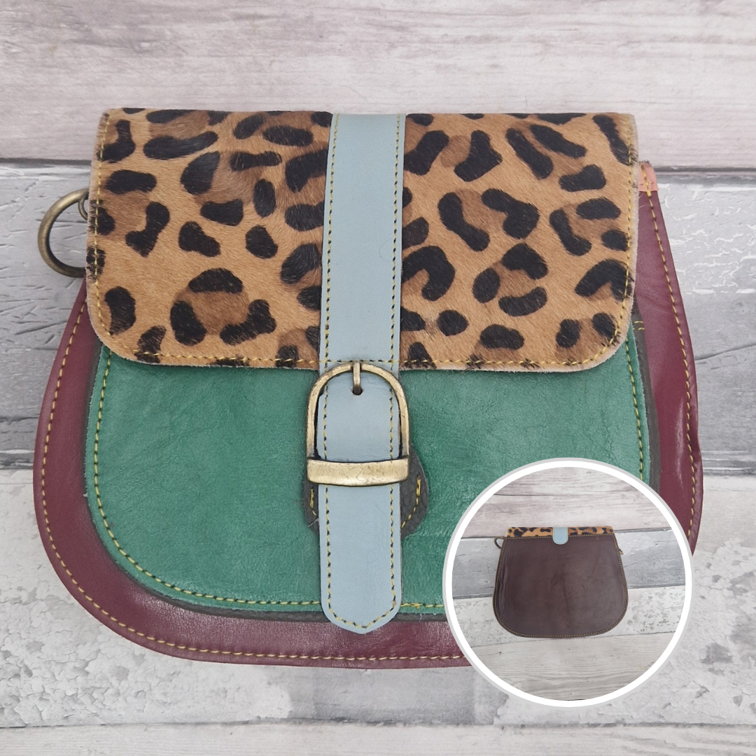 All leather saddlebag style ladies bag in 2 tones of red and green with a textured panel of leopard print. Brass buckle closer.