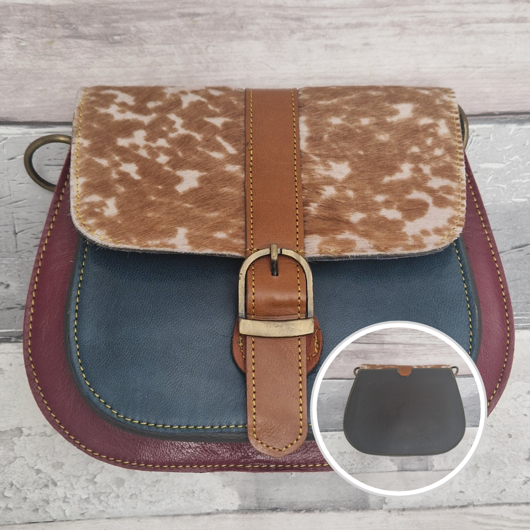 All leather saddlebag style ladies bag in 2 tones of red and blue with a textured panel of fawn print. Brass buckle closer.