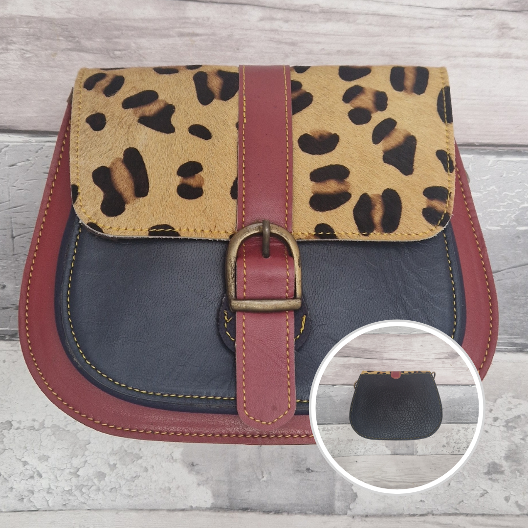 All leather saddlebag style ladies bag in 2 tones of red and navy with a textured panel of leopard print. Brass buckle closer.