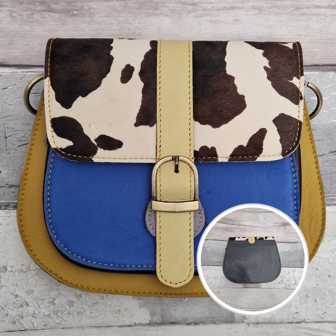 All leather saddlebag style ladies bag in 2 tones of blue and mustard with a textured panel of cow print. Brass buckle closer.