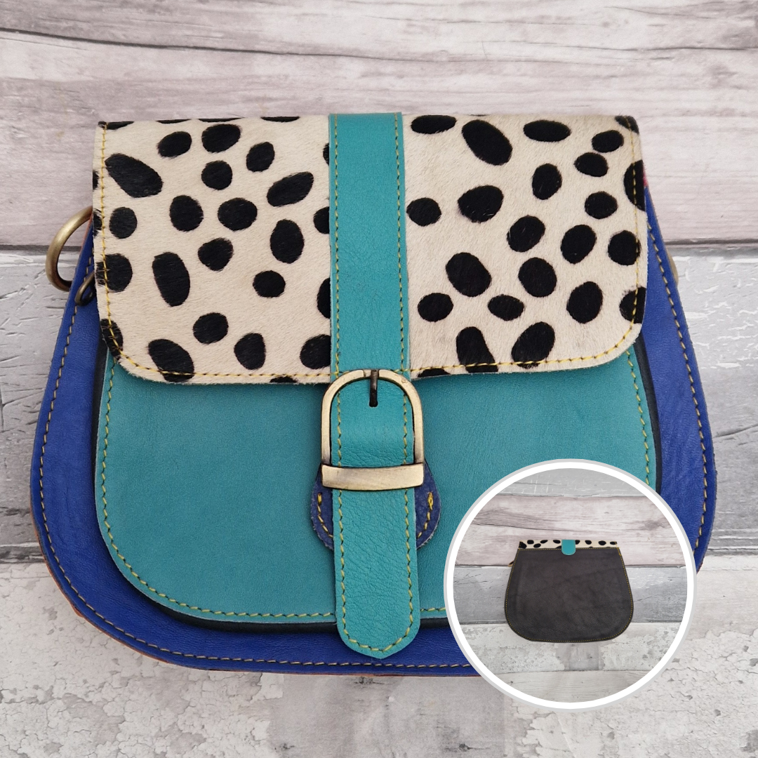 All leather saddlebag style ladies bag in 2 tones of blue with a textured panel of spot print. Brass buckle closer.