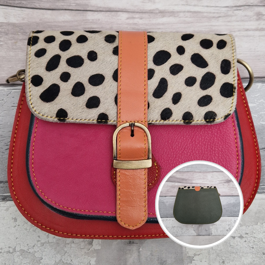 All leather saddlebag style ladies bag in 2 tones of red and pink with a textured panel of spot print. Brass buckle closer.