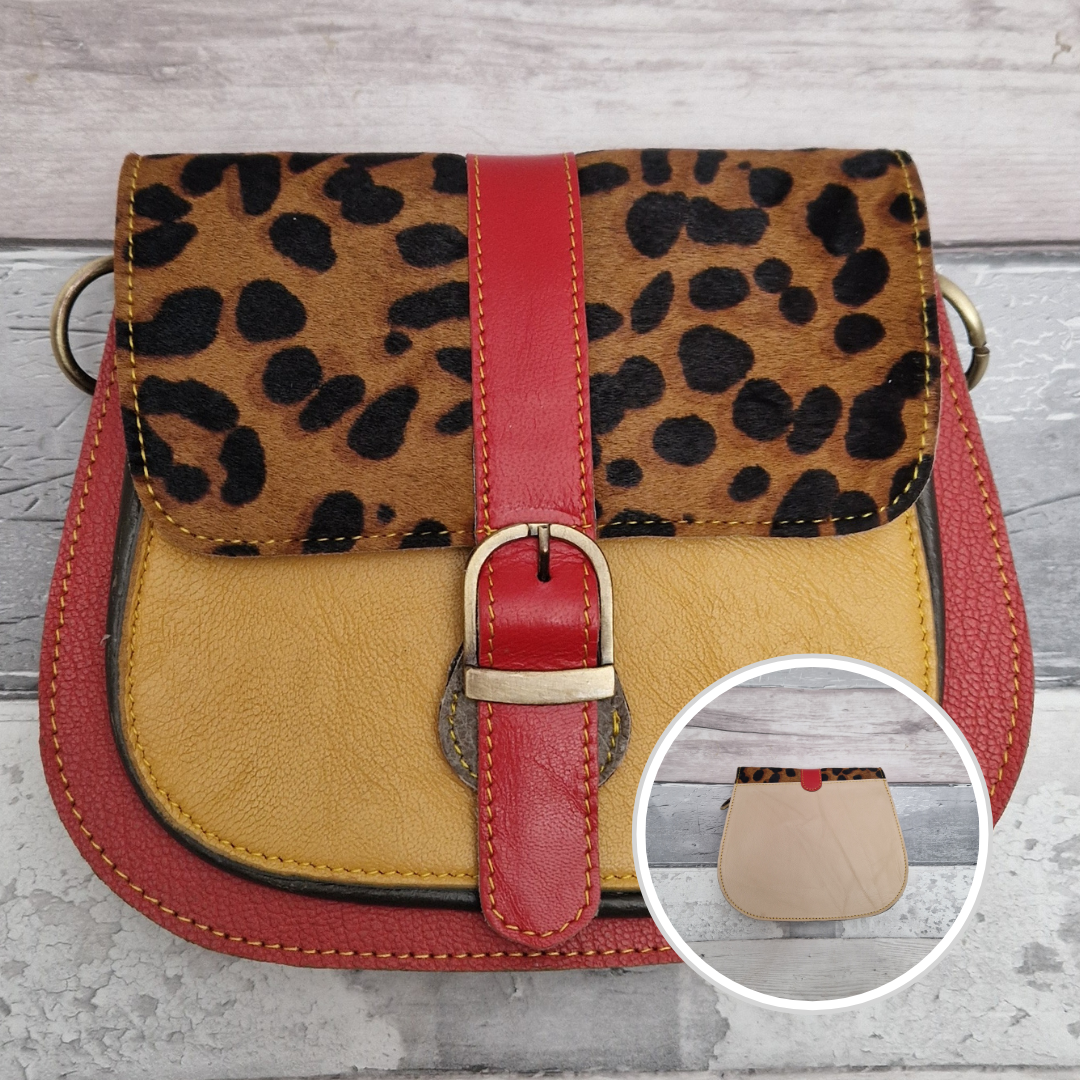 All leather saddlebag style ladies bag in 2 tones of red and mustard with a textured panel of leopard print. Brass buckle closer.