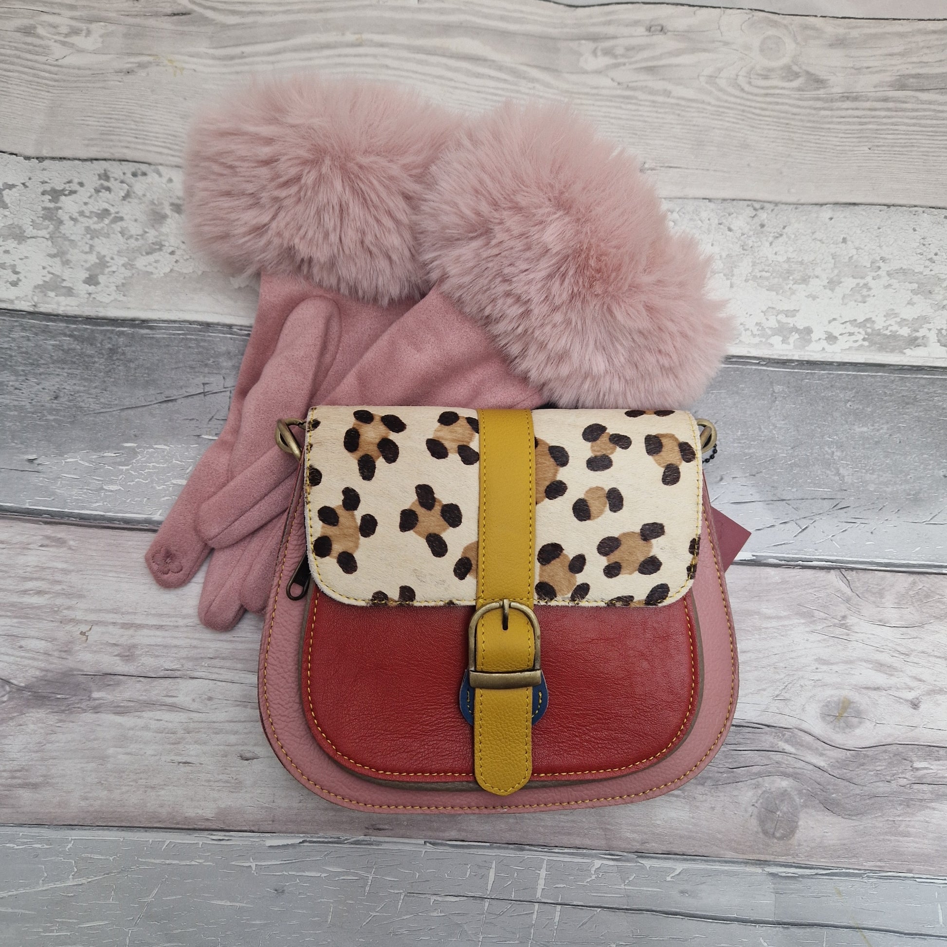 All leather saddlebag style ladies bag in 2 tones of pink and red with a textured panel of leopard print. Brass buckle closer. Matched with a pair of pink gloves with faux fur cuffs.