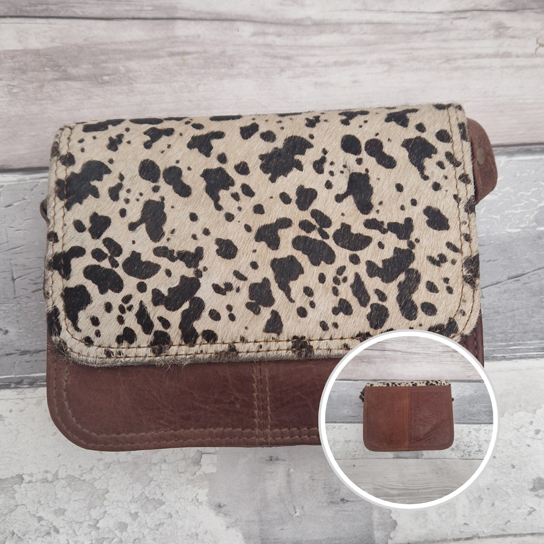 Leather bag with a textured flap of cow print.