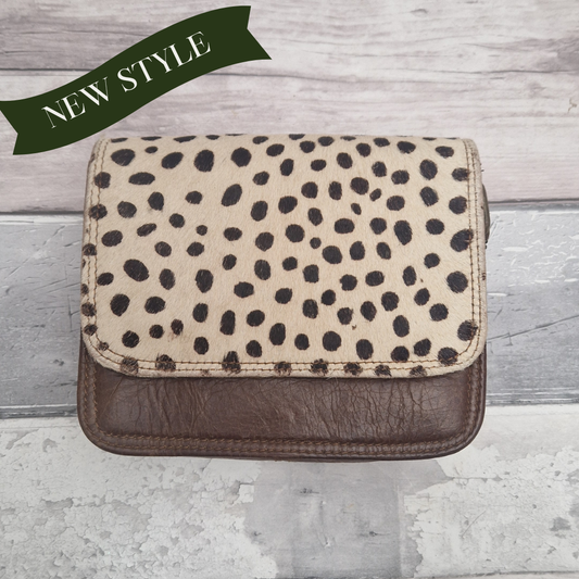 Spot print clutch bag on a wooden surface with 'NEW STYLE' text.