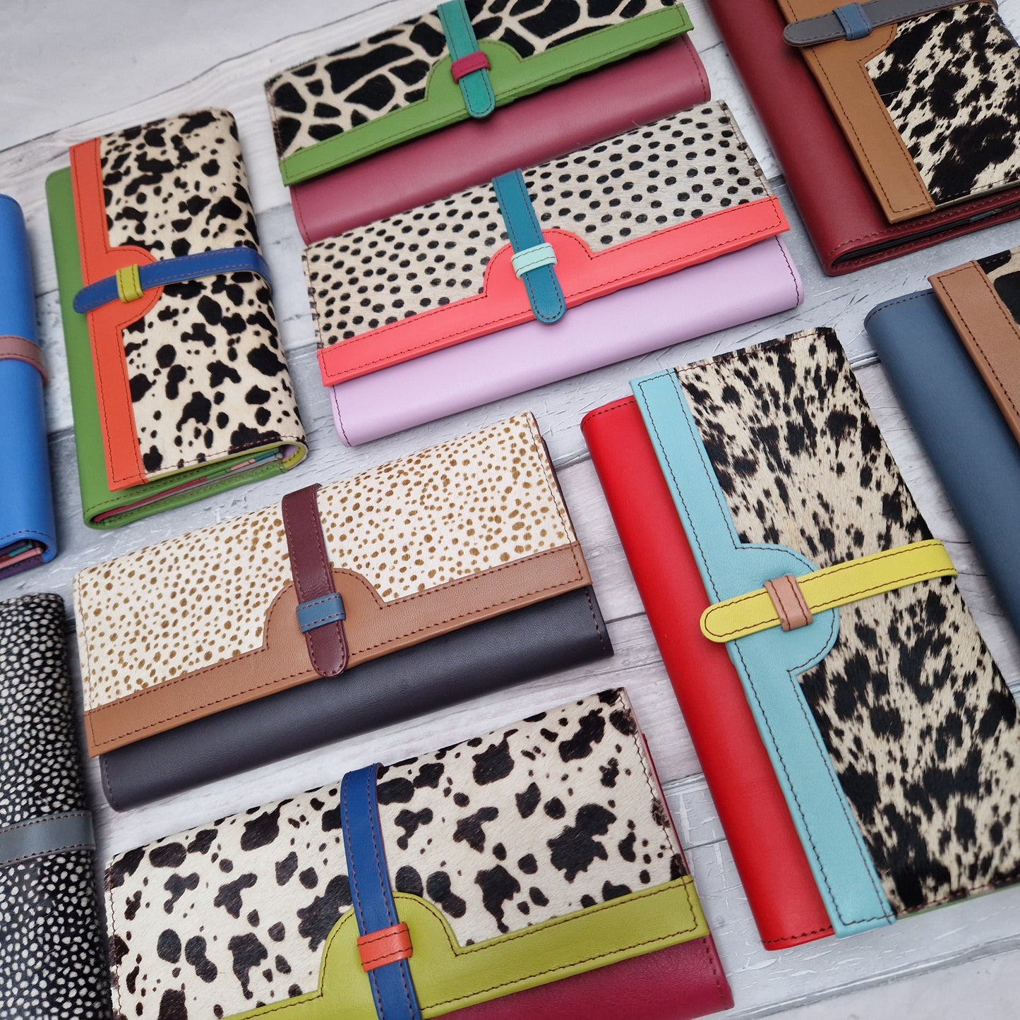 Collection of brightly coloured leather purses with textured animal print panels