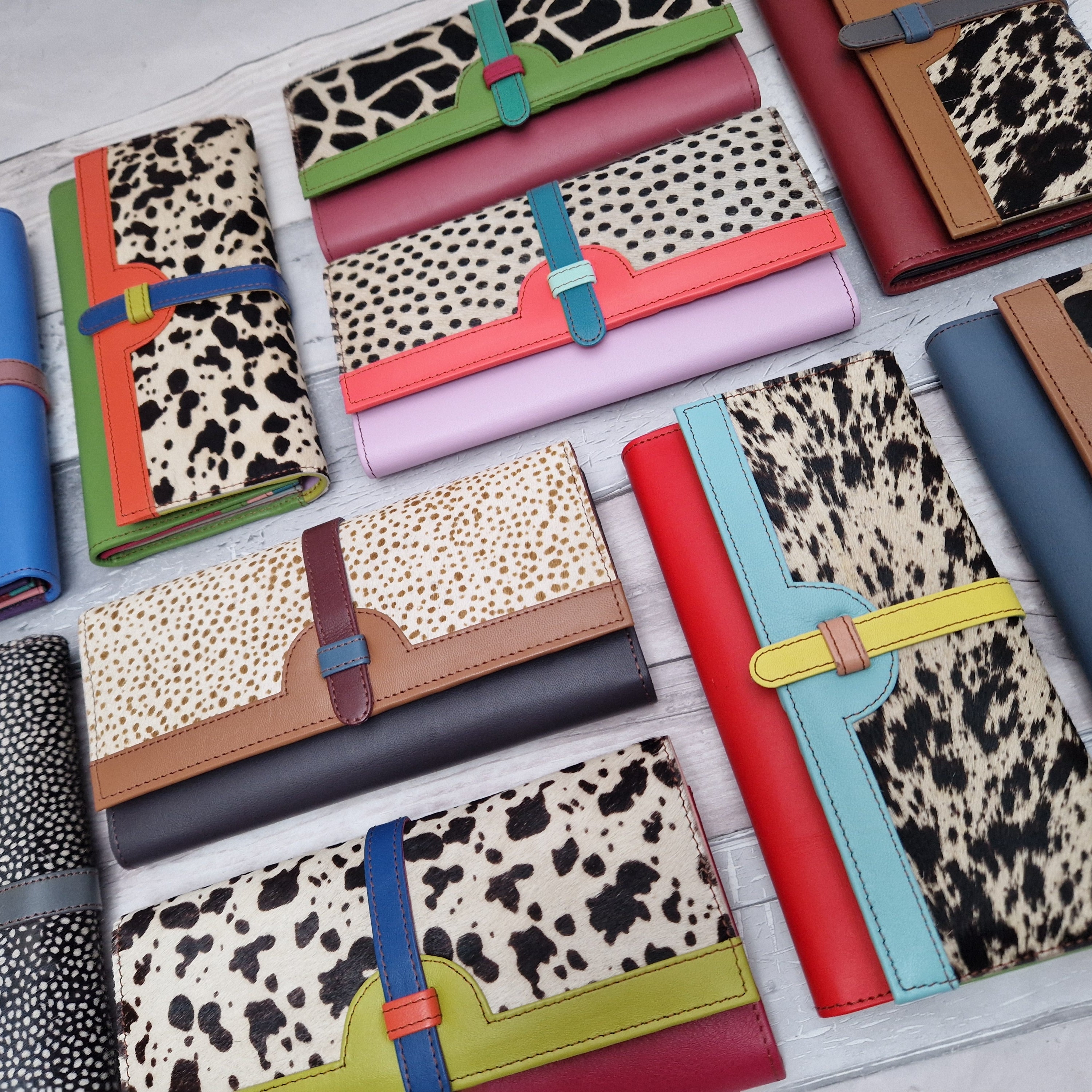 Collection of brightly coloured leather purses with textured animal print panels