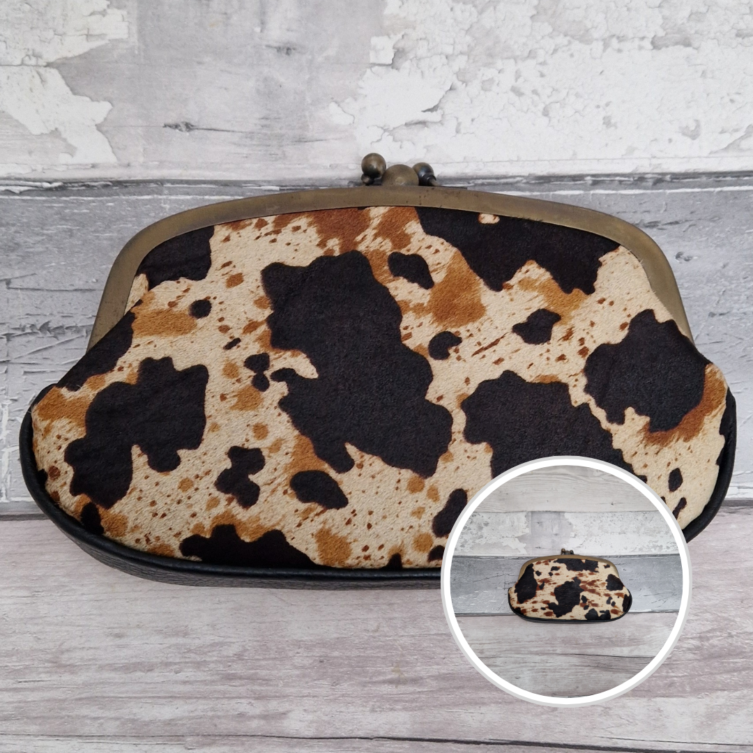 Cow print clutch bag on a wooden surface with a close-up inset.