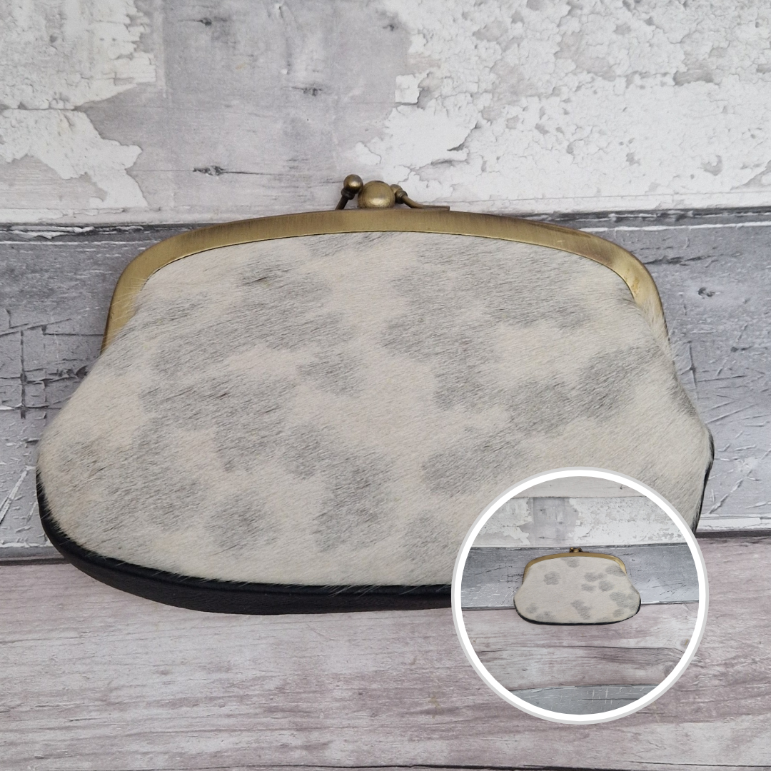 Vintage-style clutch bag with brass clasp on a wooden surface