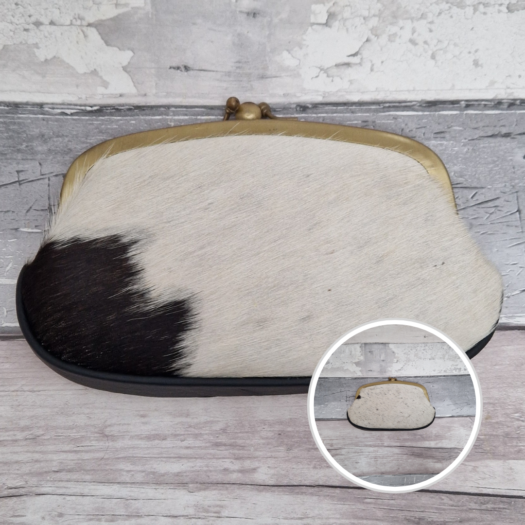 Clutch bag with cowhide leather design on a wooden surface