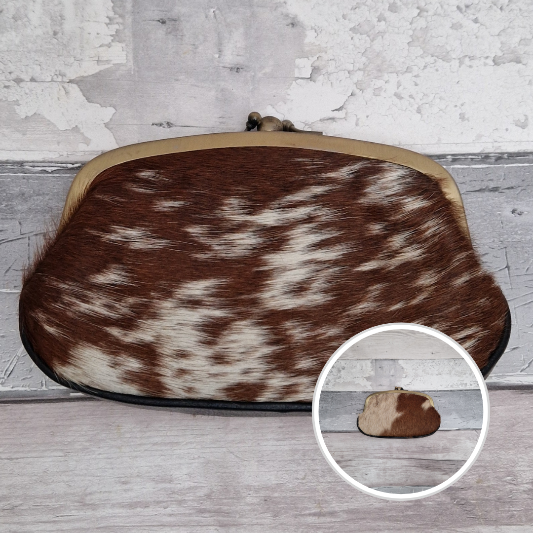 Clutch bag with brown and white cowhide pattern on a wooden surface