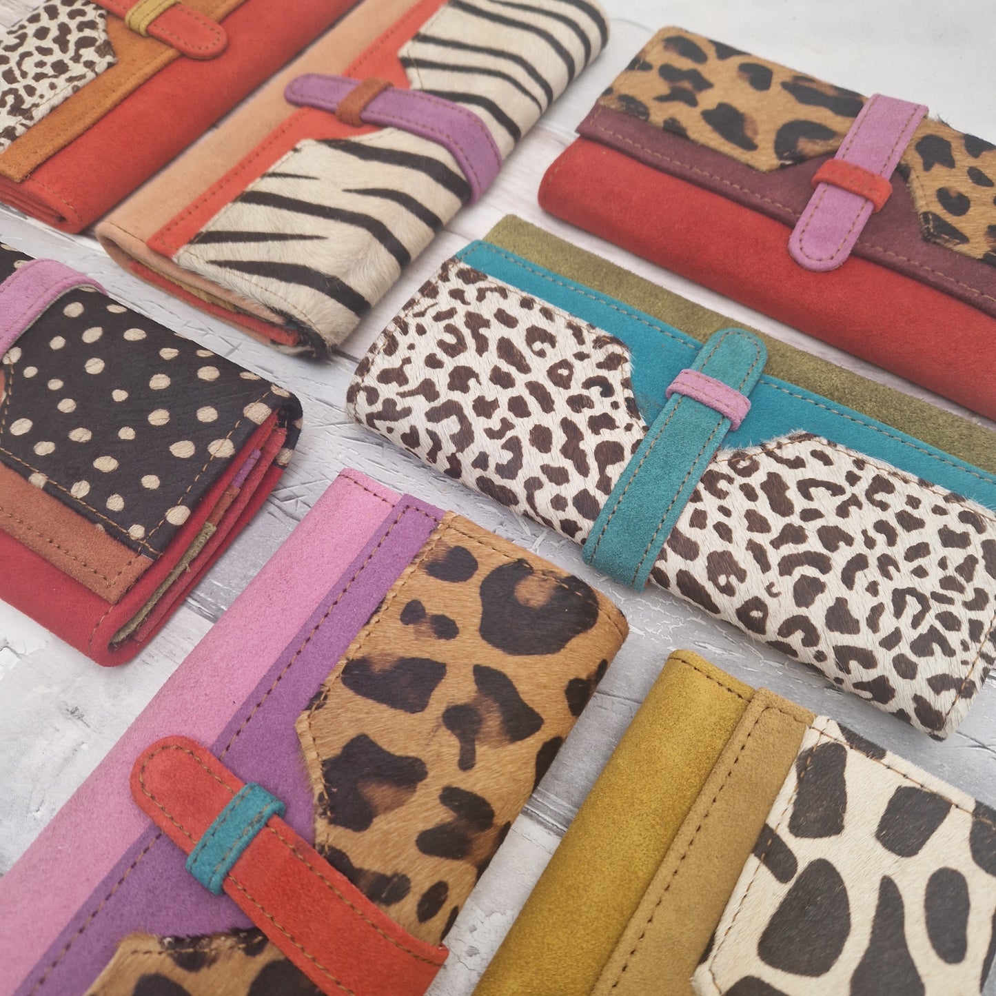 Collection of colorful wallets with animal print patterns on a light background