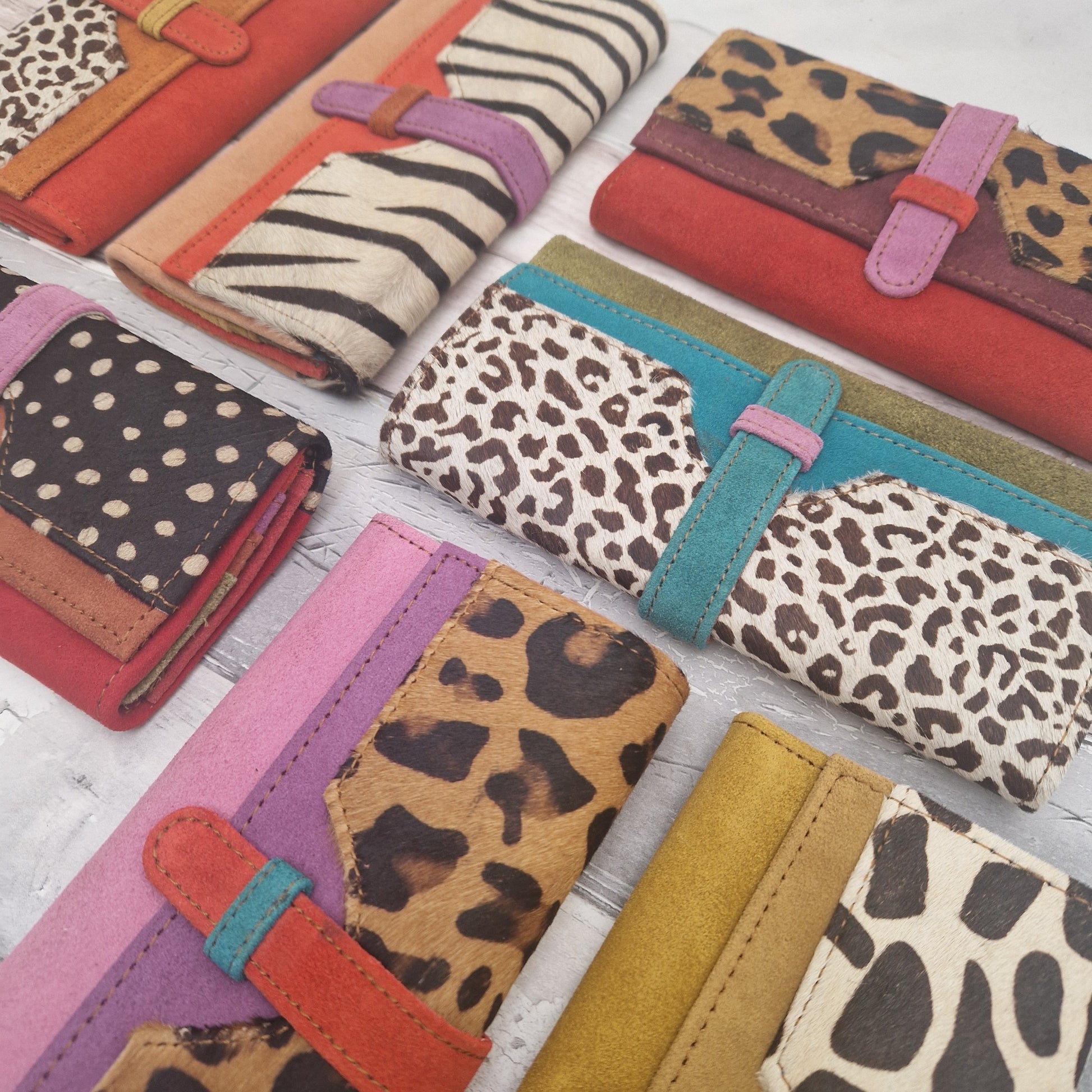 Collection of colorful wallets with animal print patterns on a light background