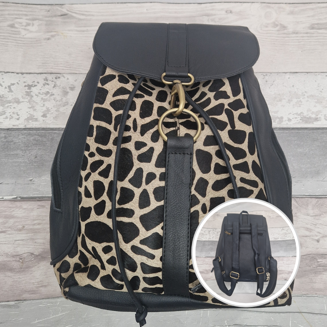 Dark navy all leather backpack with textured panels of black and white giraffe print.