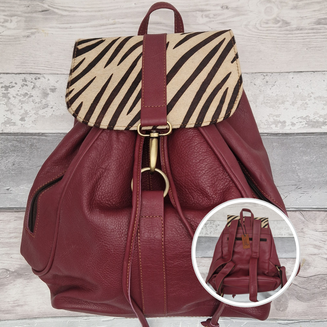 Burgundy leather back pack with textured panels of black and white zebra print.
