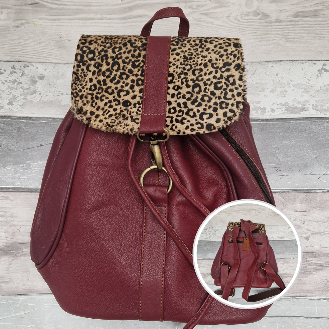 Burgundy leather back pack with textured panels of cheetah print.