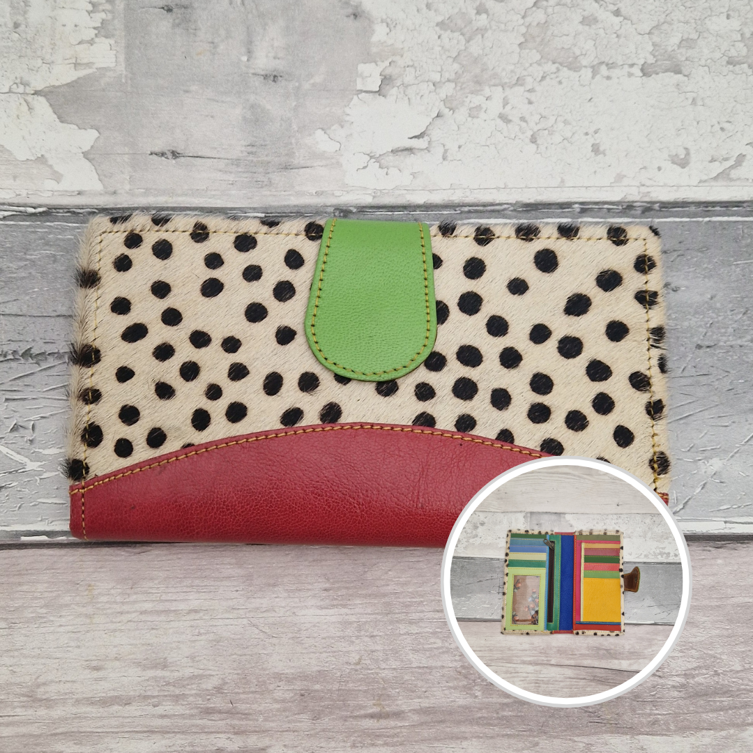 All leather wallet style purse made from multi-coloured pieces with a raspberry front panel and textured spot print cover.