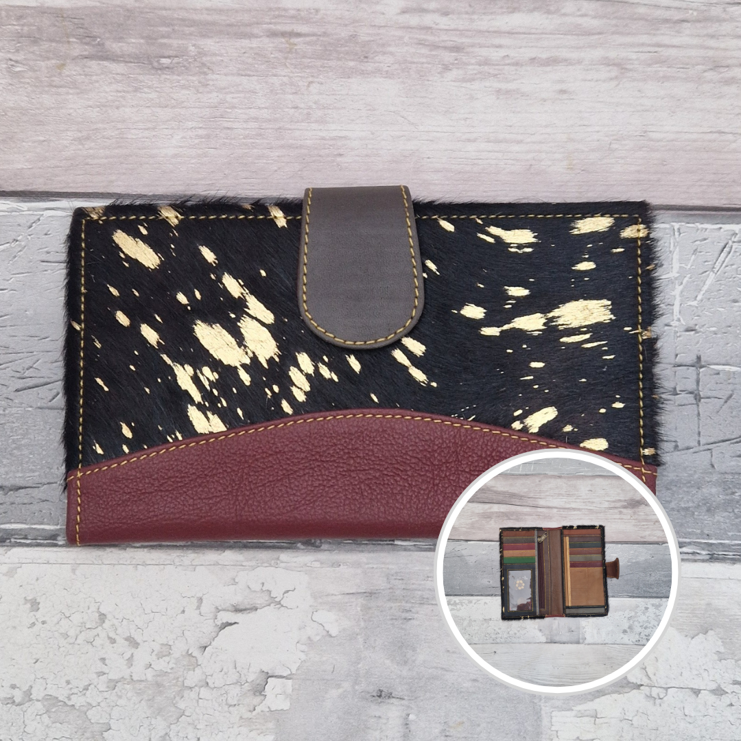 All leather wallet style purse made from multi-coloured pieces with a dark red front panel and textured metallic pony print cover.