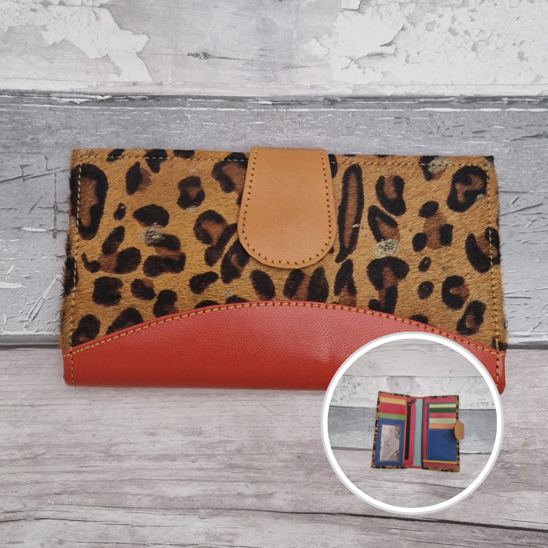 All leather wallet style purse made from multi-coloured pieces with a dark orange front panel and textured metallic leopard print cover.