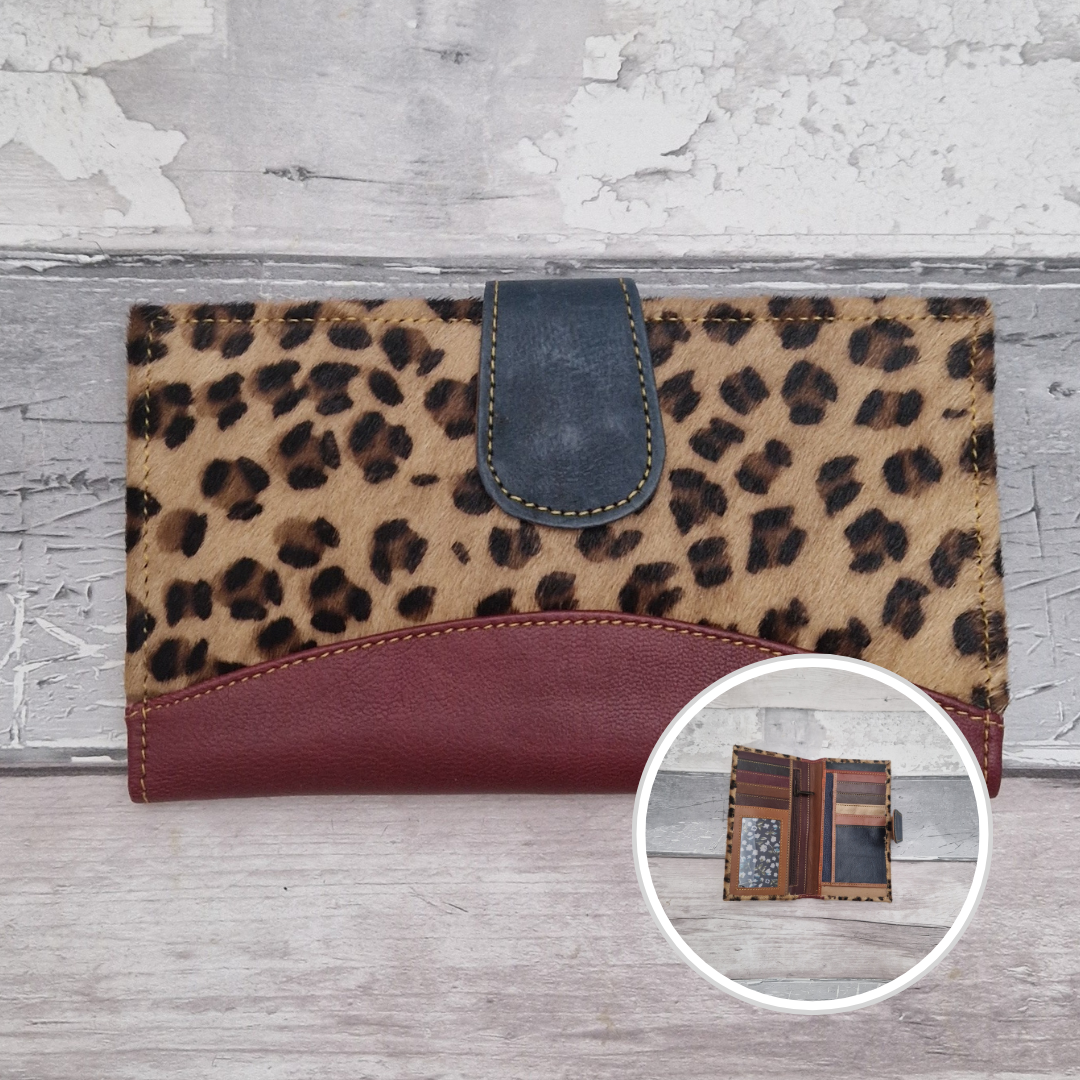All leather wallet style purse made from multi-coloured pieces with a burgundy front panel and textured leaoprd print cover.