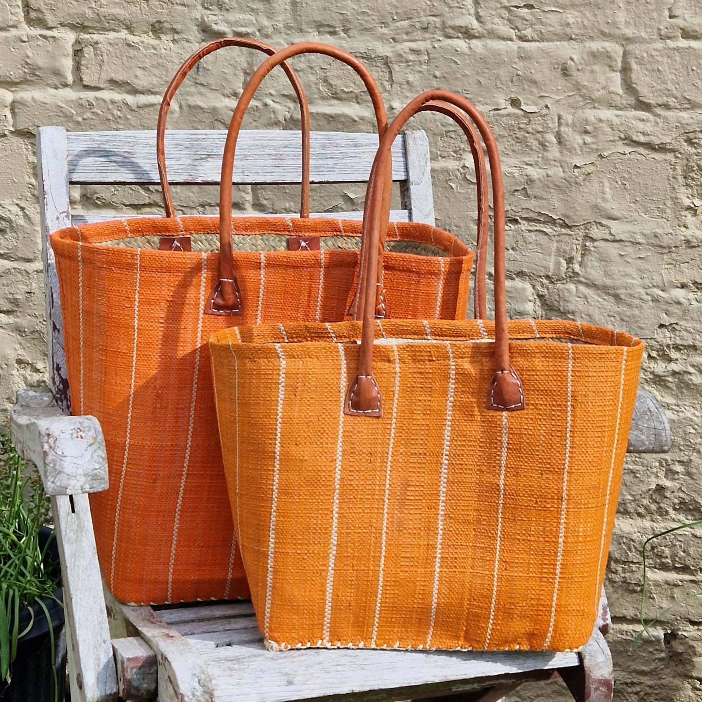 Bright Orange Raffia Basket with vertical pinstripe pattern.