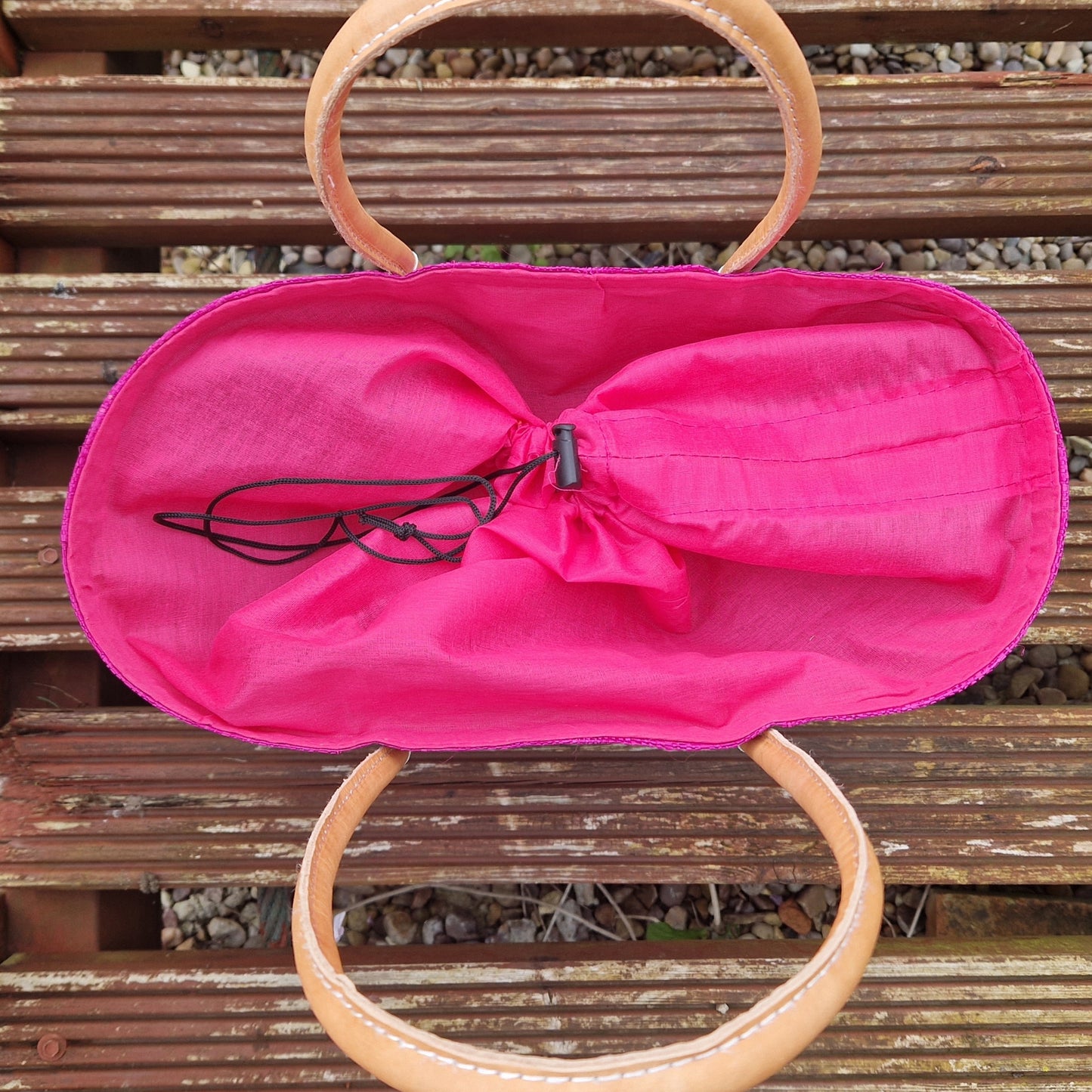 Top down view of pink raffia basket with drawstring top.