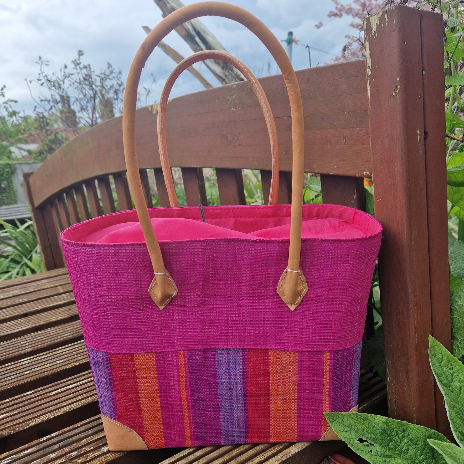 Magenta coloured raffia baskets with bright stripes