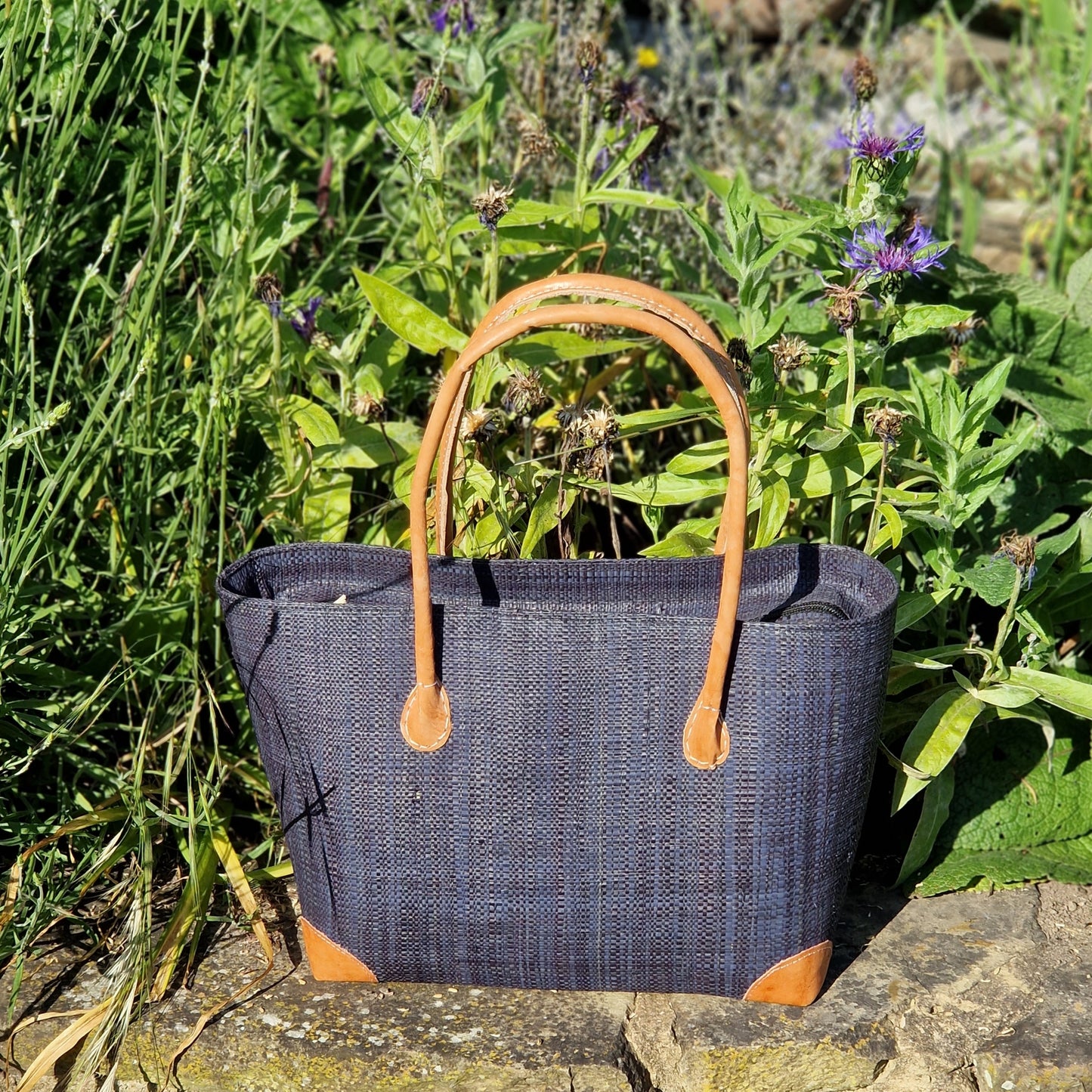 Black Raffia Basket with leather handles and a zip top.