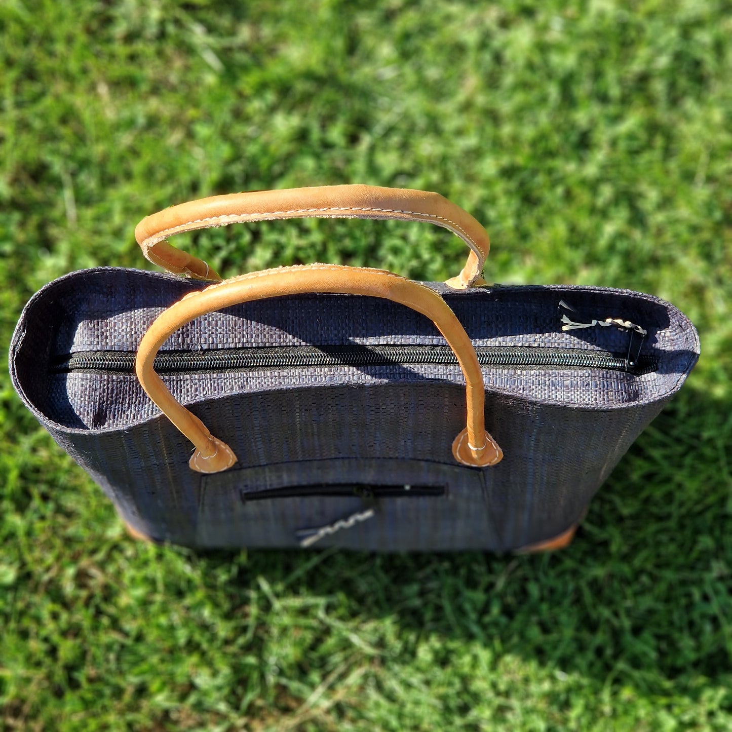 Black Raffia Basket with leather handles and a zip top.