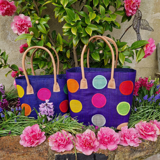 Pair of Royal Blue Raffia baskets decorated with rainbow coloured spots.