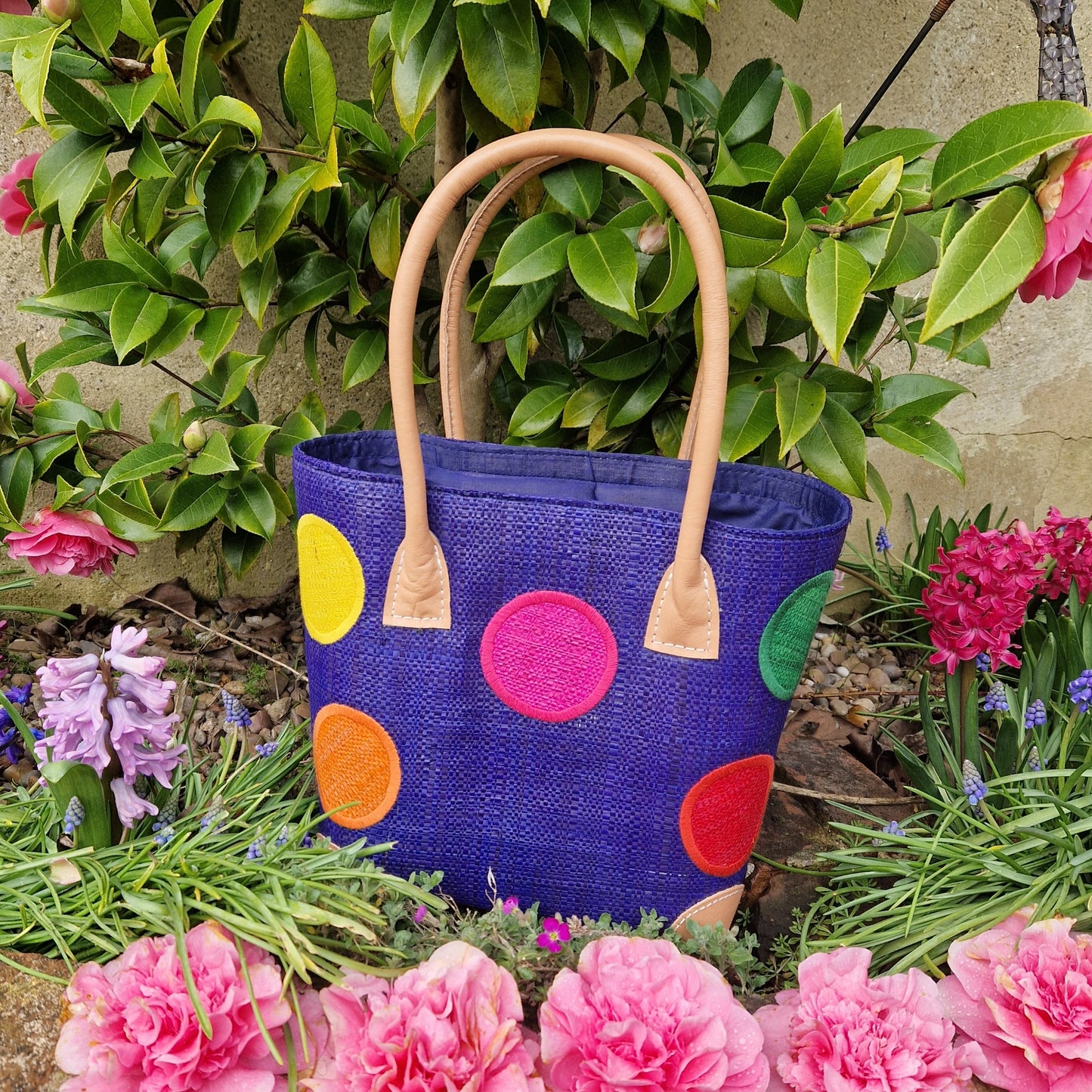 Royal Blue Raffia baskets decorated with rainbow coloured spots.