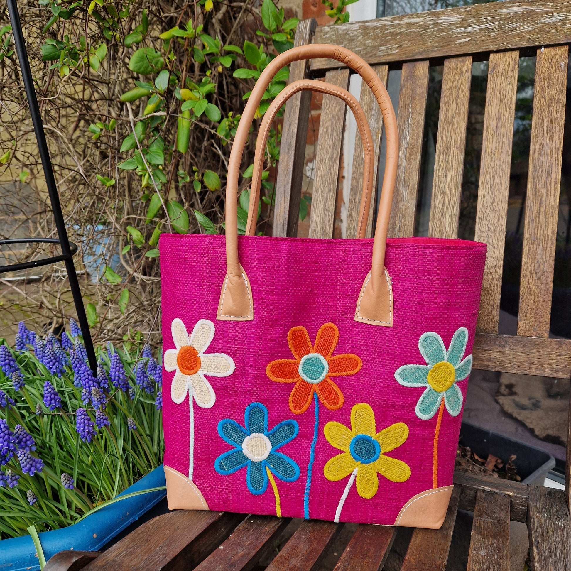 Hot Pink coloured Raffia Basket with brightly coloured flowers on the front.