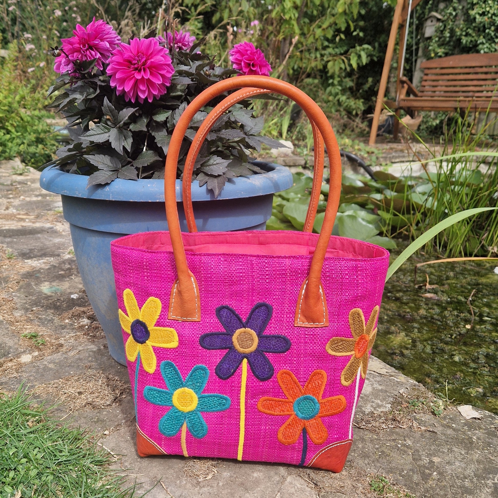 Hot Pink coloured Raffia Basket with brightly coloured flowers on the front.