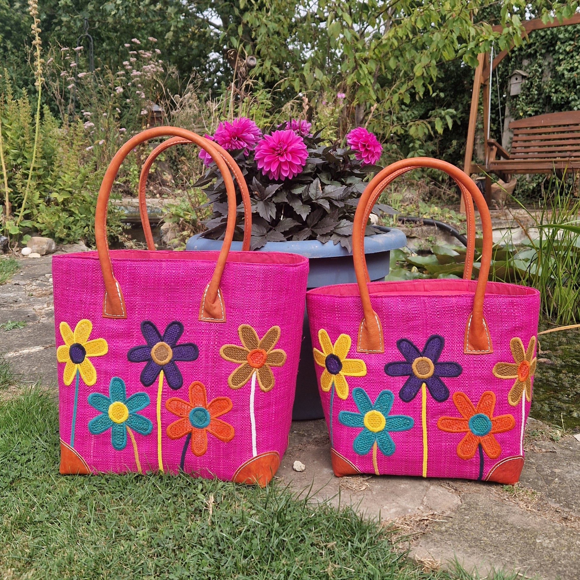 Hot Pink coloured Raffia Basket with brightly coloured flowers on the front.