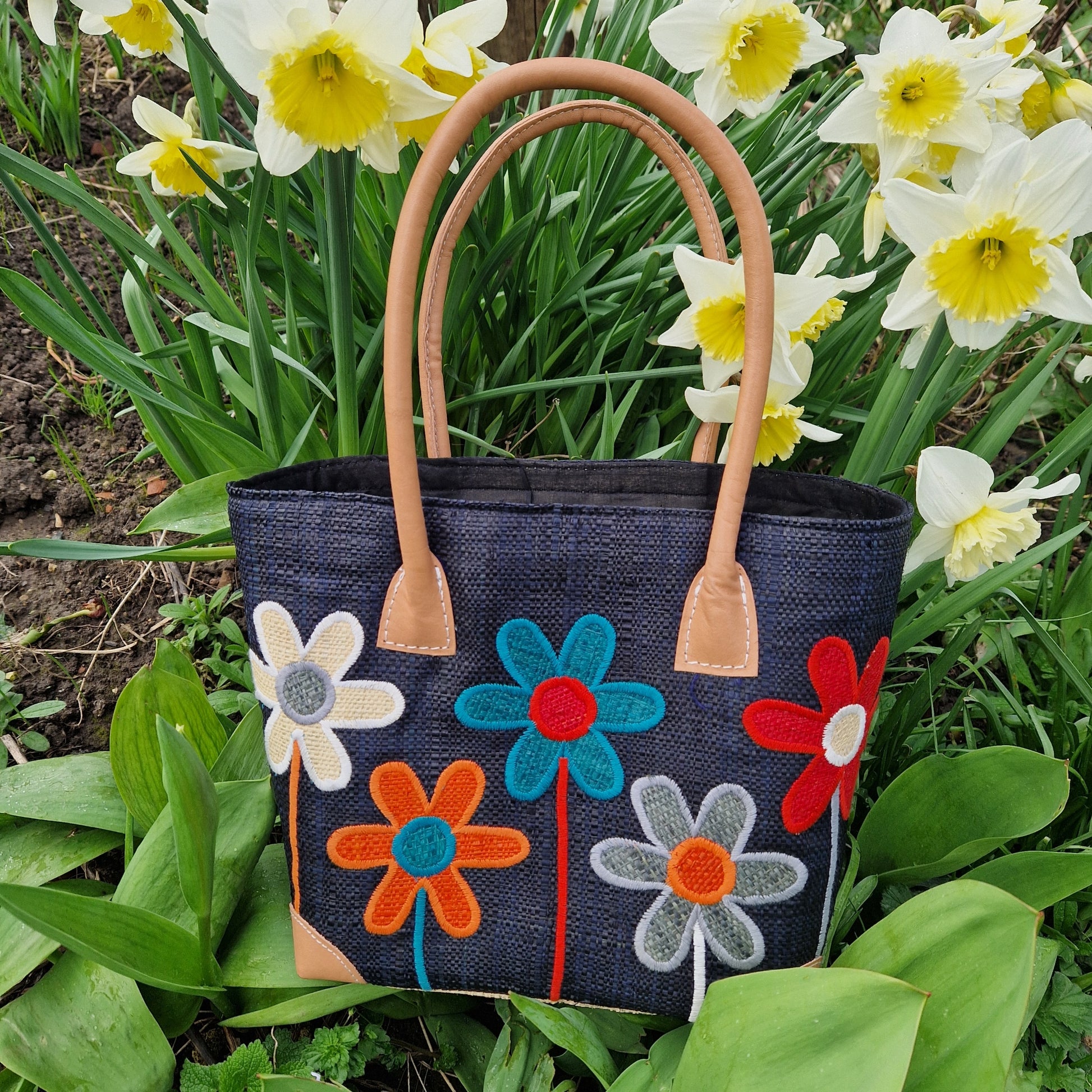 Black Raffia Baskets decorated with a mix of coloured flowers.