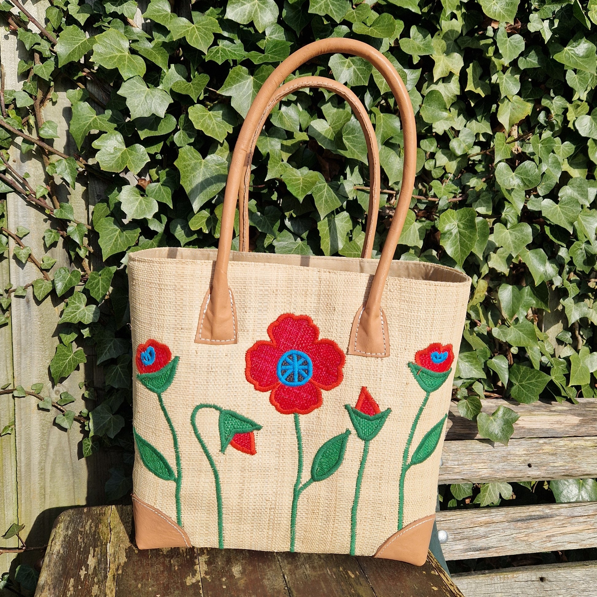 Natural Raffia Basket decorated with red poppies on the front.