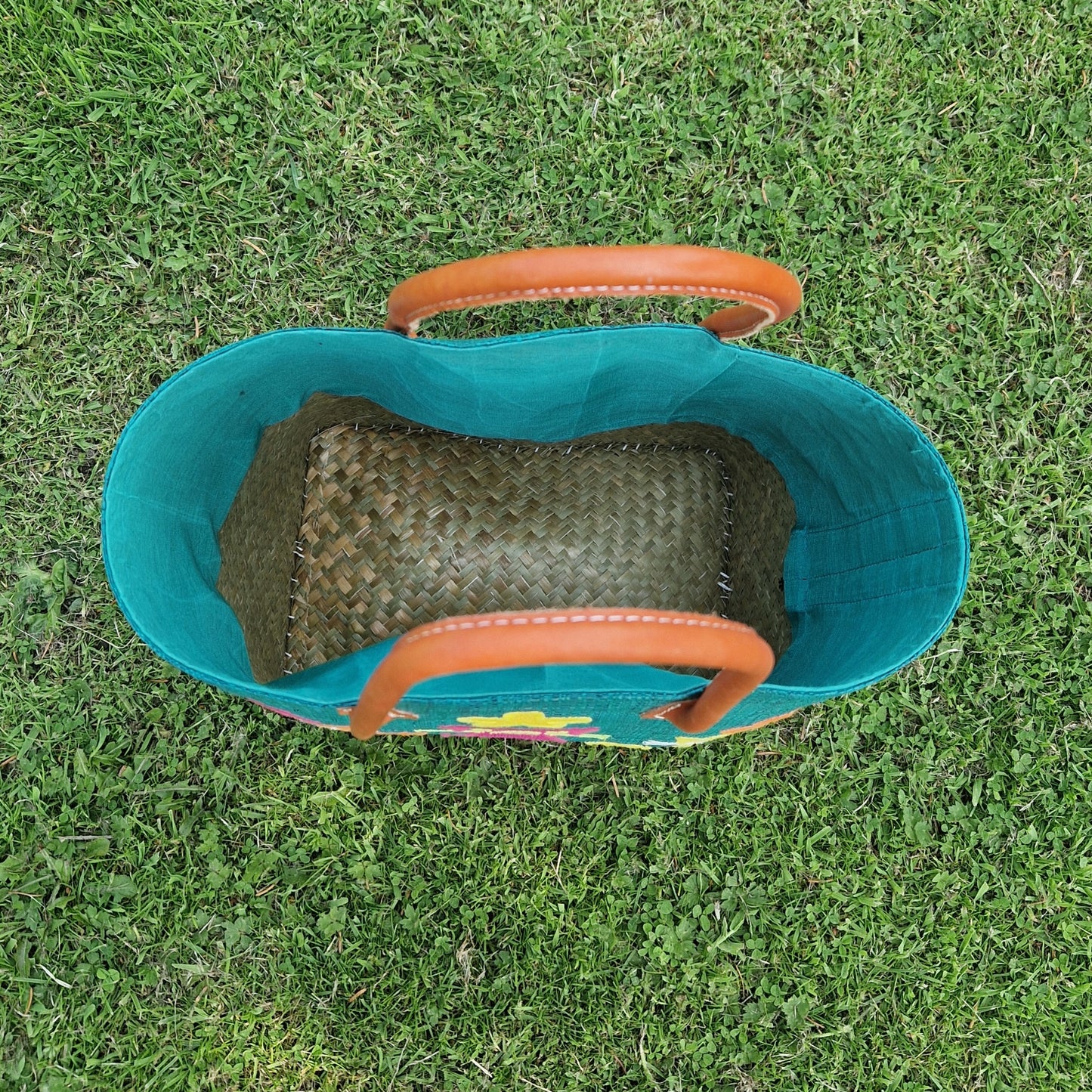 Top down view into a turquoise coloured raffia basket.