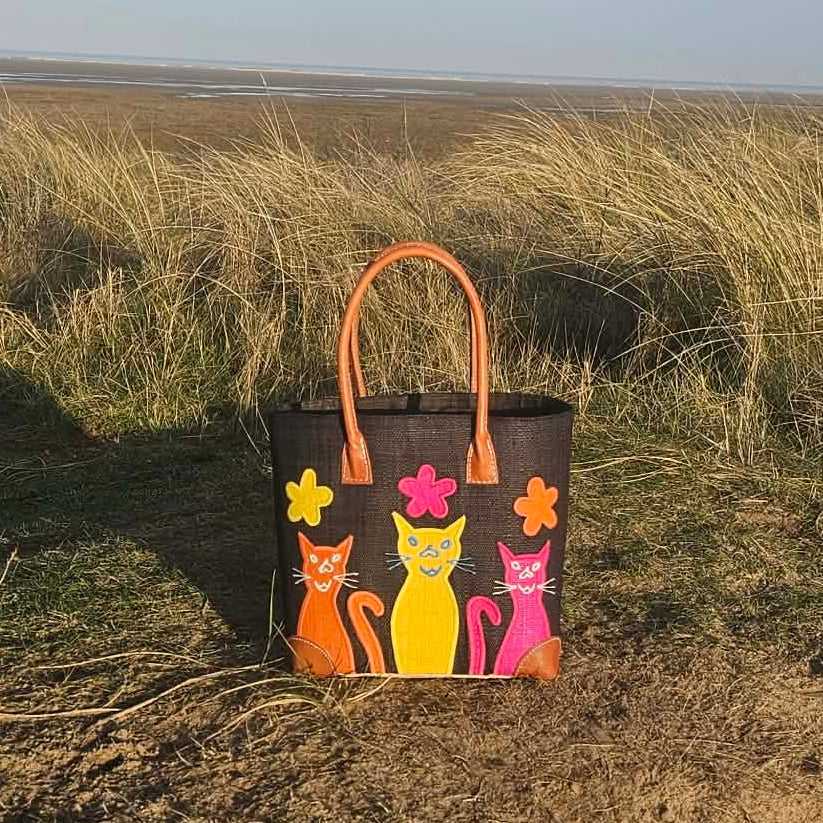 Black Raffia Baskets decorated with colourful cheeky cats in bright pink, yellow and orange.