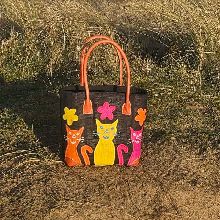Black Raffia Baskets decorated with colourful cheeky cats in bright pink, yellow and orange.