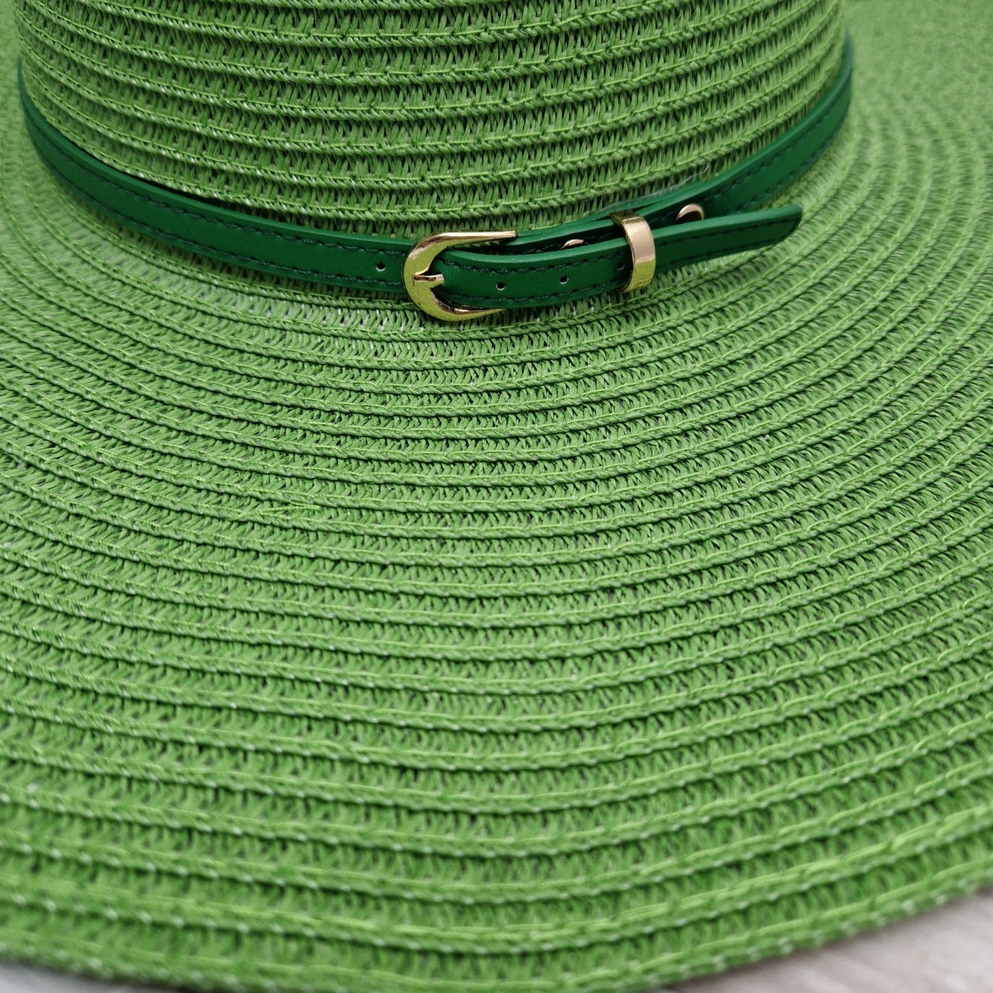 Wide brimmed emerald green hat with matching belted band.