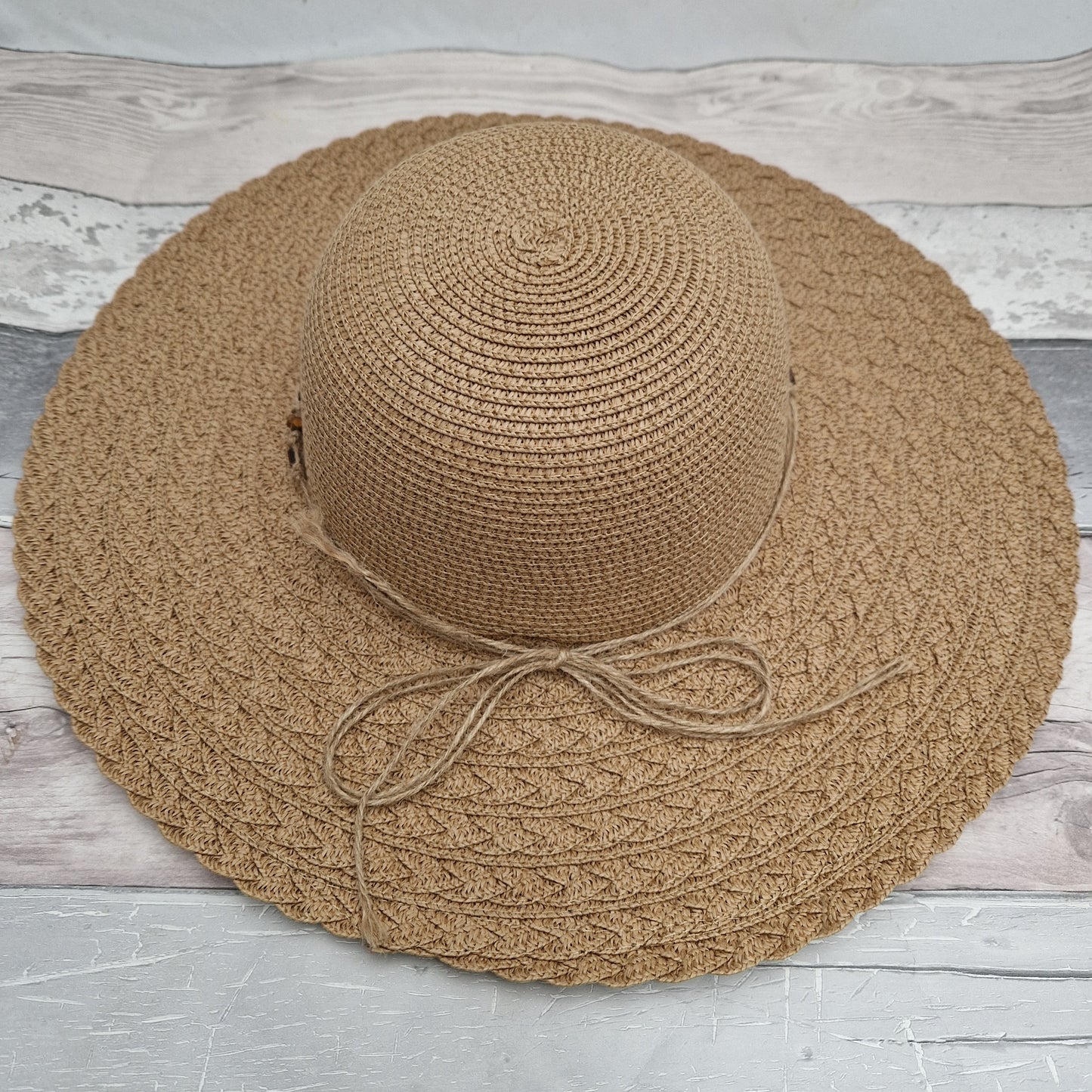 Natural coloured wide brimmed hat with a beaded band.