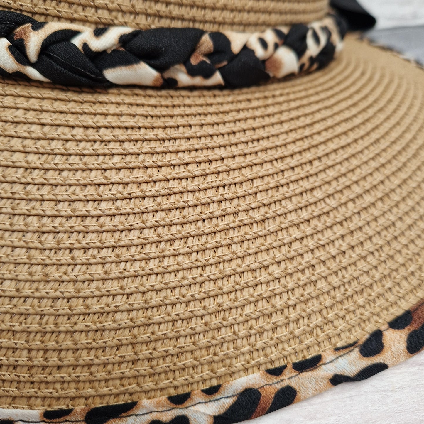 Natural Biscuit coloured open backed hat with an animal print trim and black bow.